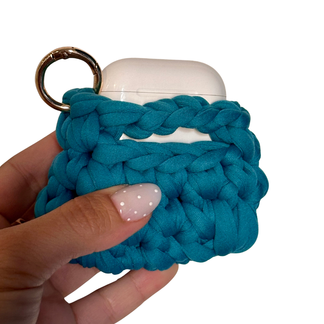 Custodia AirPods verde petrolio agganciata a una borsa con moschettone